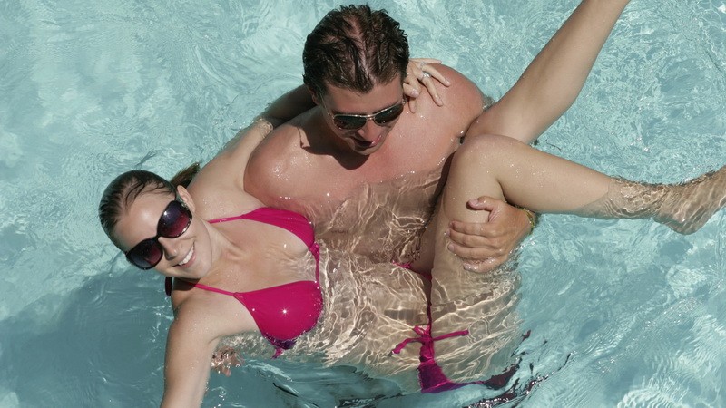 Muž drží ženu v rukách, bazén, Chorvátsko